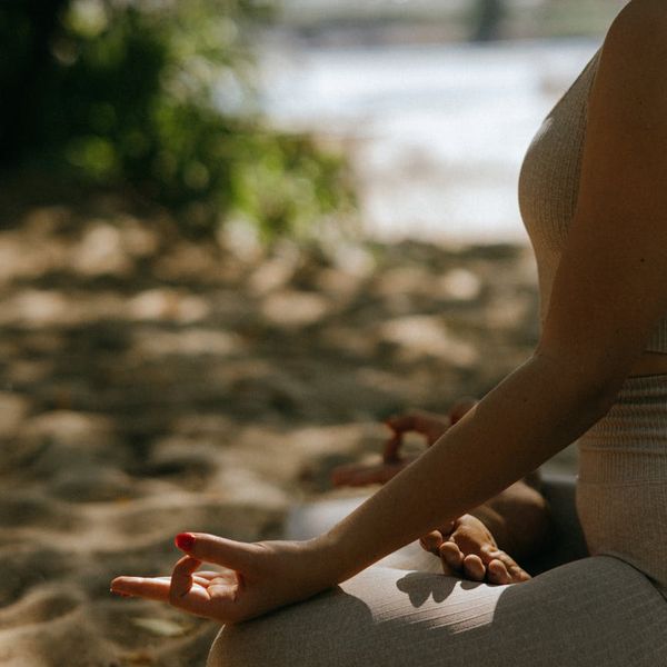 Person meditating peacefully in a serene natural environment.